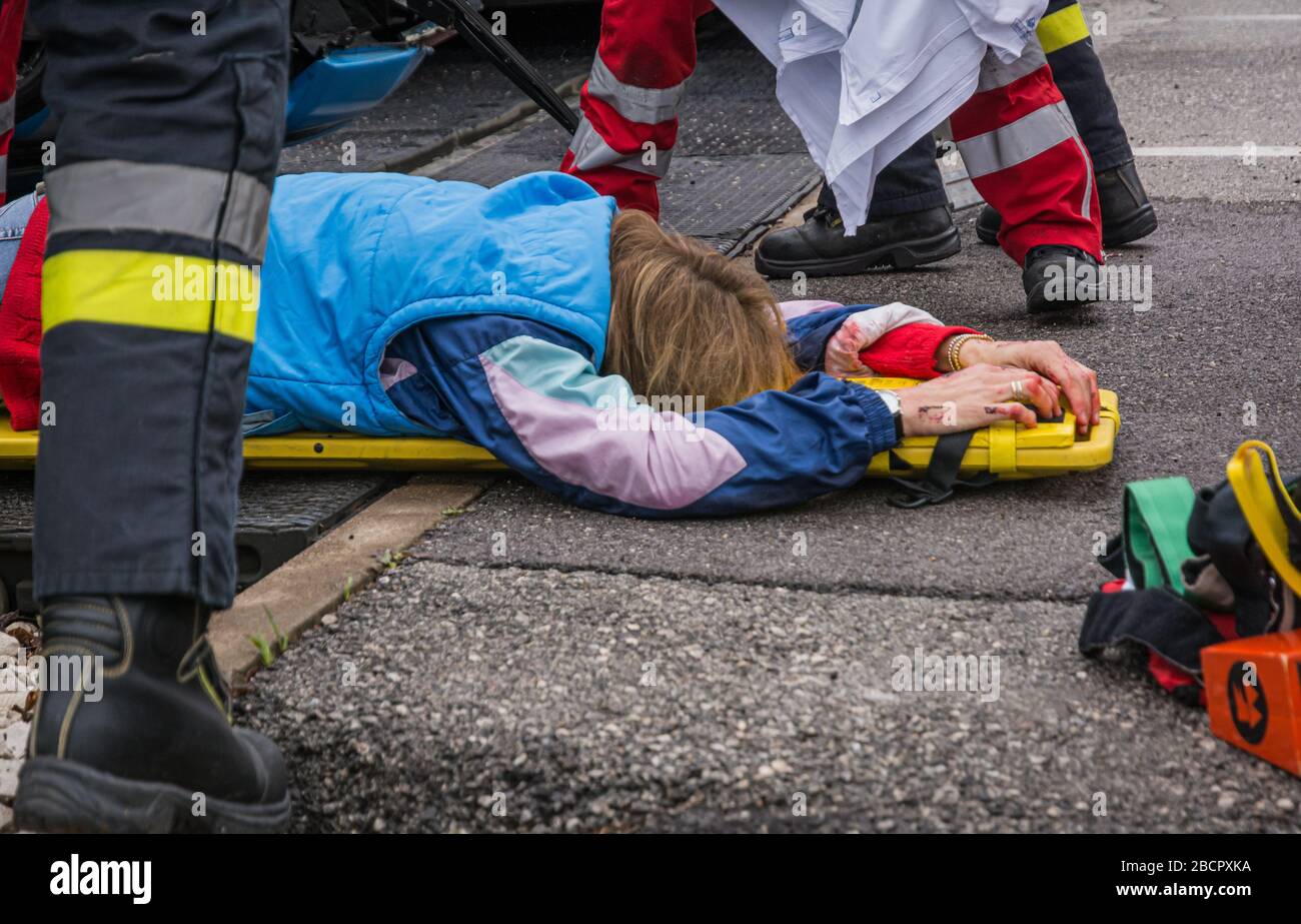 Emergency service personnel free an injured driver at the scene of a traffic accident during a training exercise.  firefighters, paramedics and Italia Stock Photo