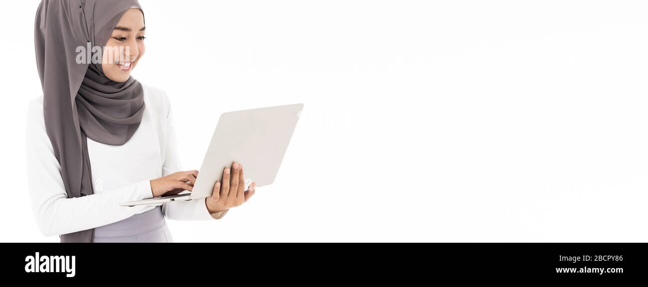Asian young adult woman wearing hijab using laptop work from home to ...