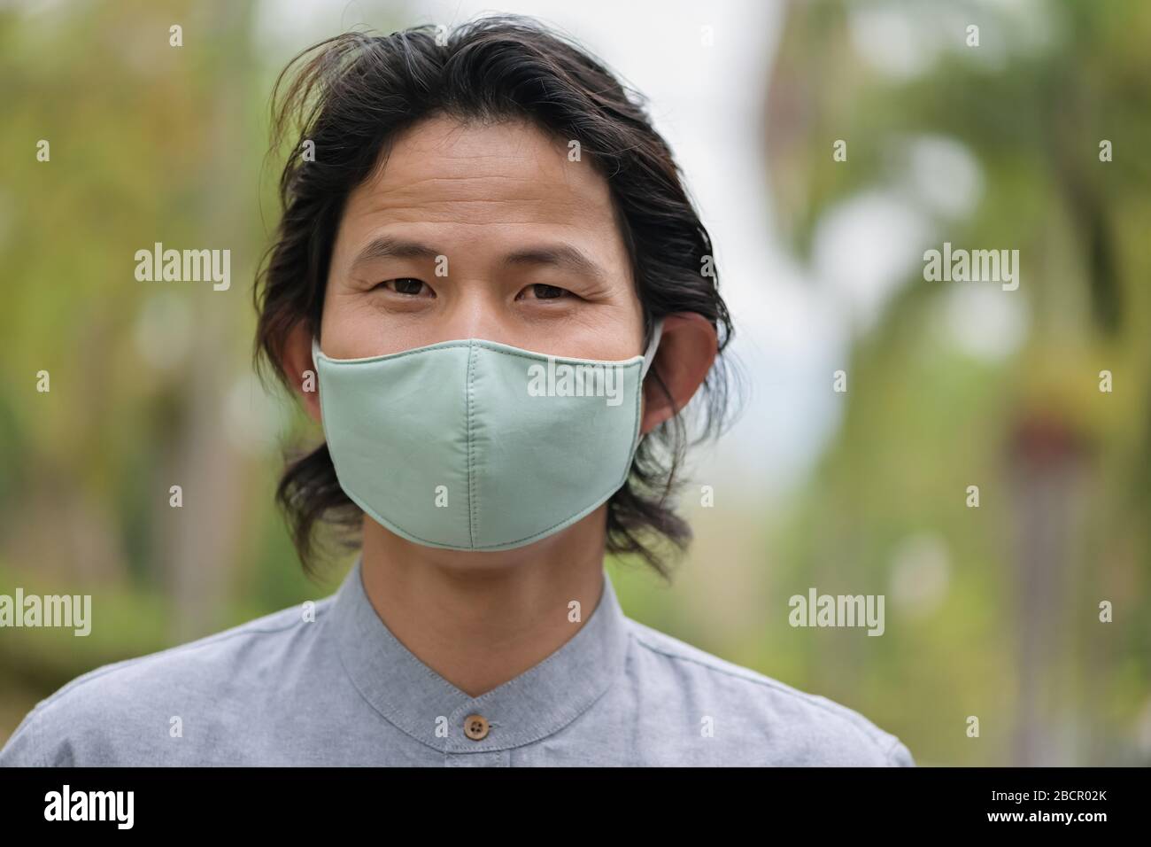 Man wearing a cloth mask in public area protect himself from risk of disease, people prevent infection from coronavirus Covid-19 or Air pollution Stock Photo