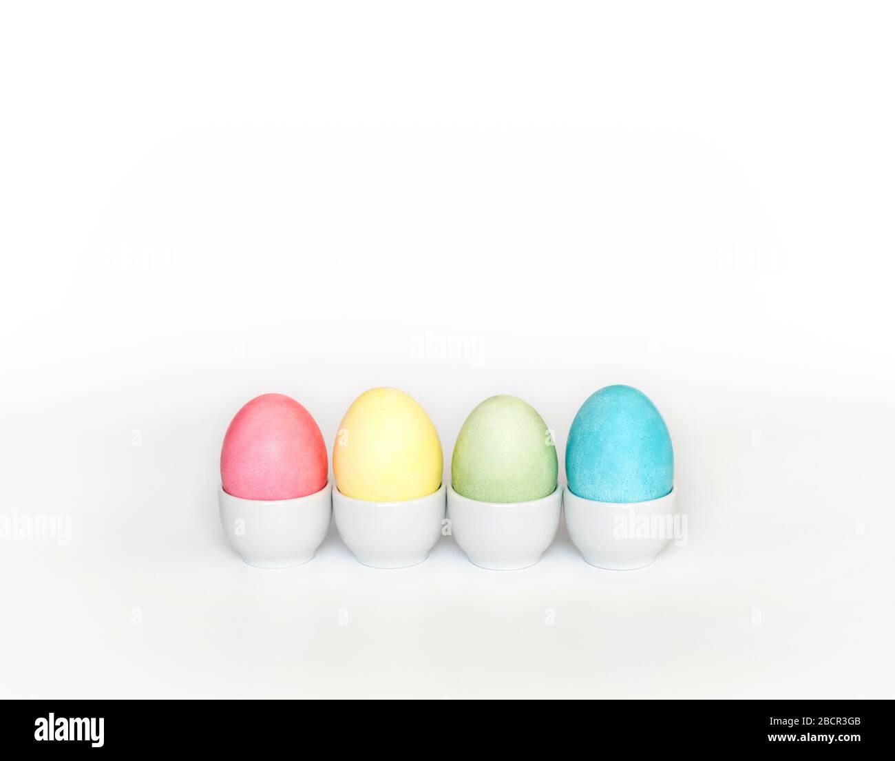 Colorful Easter eggs in stands on a white background. Easter concept. Copy space. Stock Photo