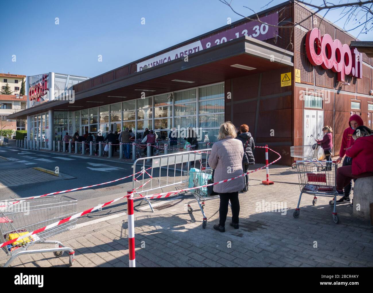 Florence, Italy - 2020, April 4: European consumers in line at the supermarket for grocery shopping, during Corona Virus pandemic emergency. Stock Photo