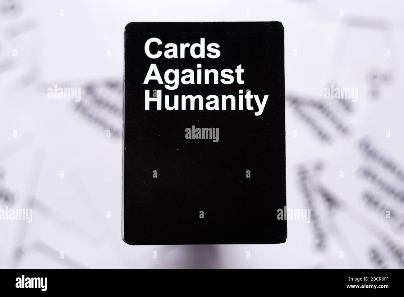 Cards against humanity deck stacked straight on top of other white cards in  the background. Background completely blurred Stock Photo - Alamy