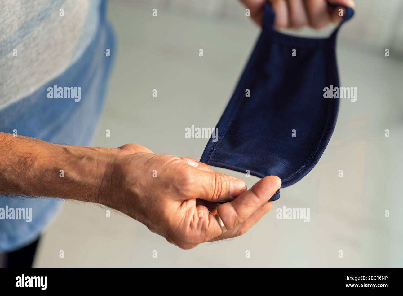 Person hand holding medical mask for protection against flu, disease, novel coronavirus (covid 19). Background concept for Corona Virus, staying at ho Stock Photo