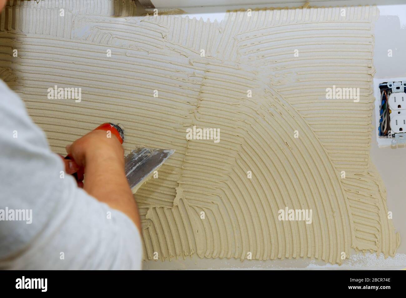 Handyman applying ceramic tiles on bathroom walls in bathroom during renovation Stock Photo Alamy
