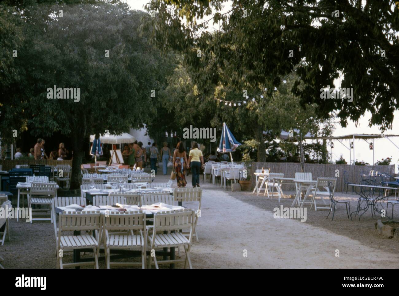 People walking along a promenade by cafes and restaurants in St Maxime, South of France, 1973 Stock Photo