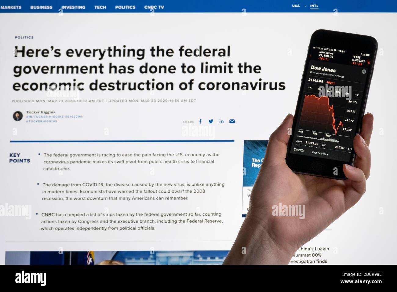 Covid 19 Federal Government Information & Smartphone showing Dow Jones Market decline Stock Photo