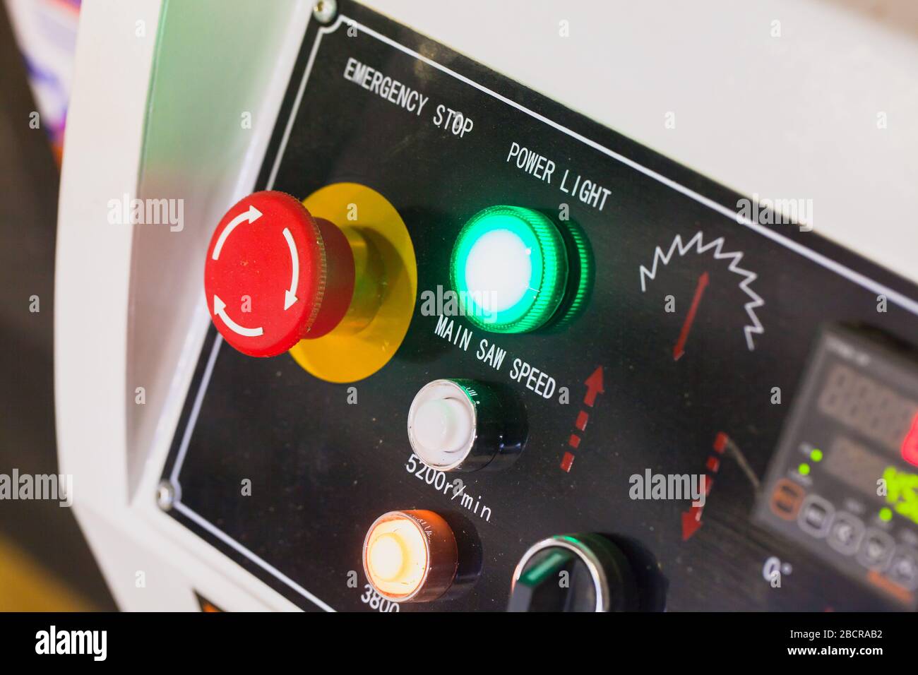 Industrial equipment control panel with red emergency stop button, closeup photo with selective