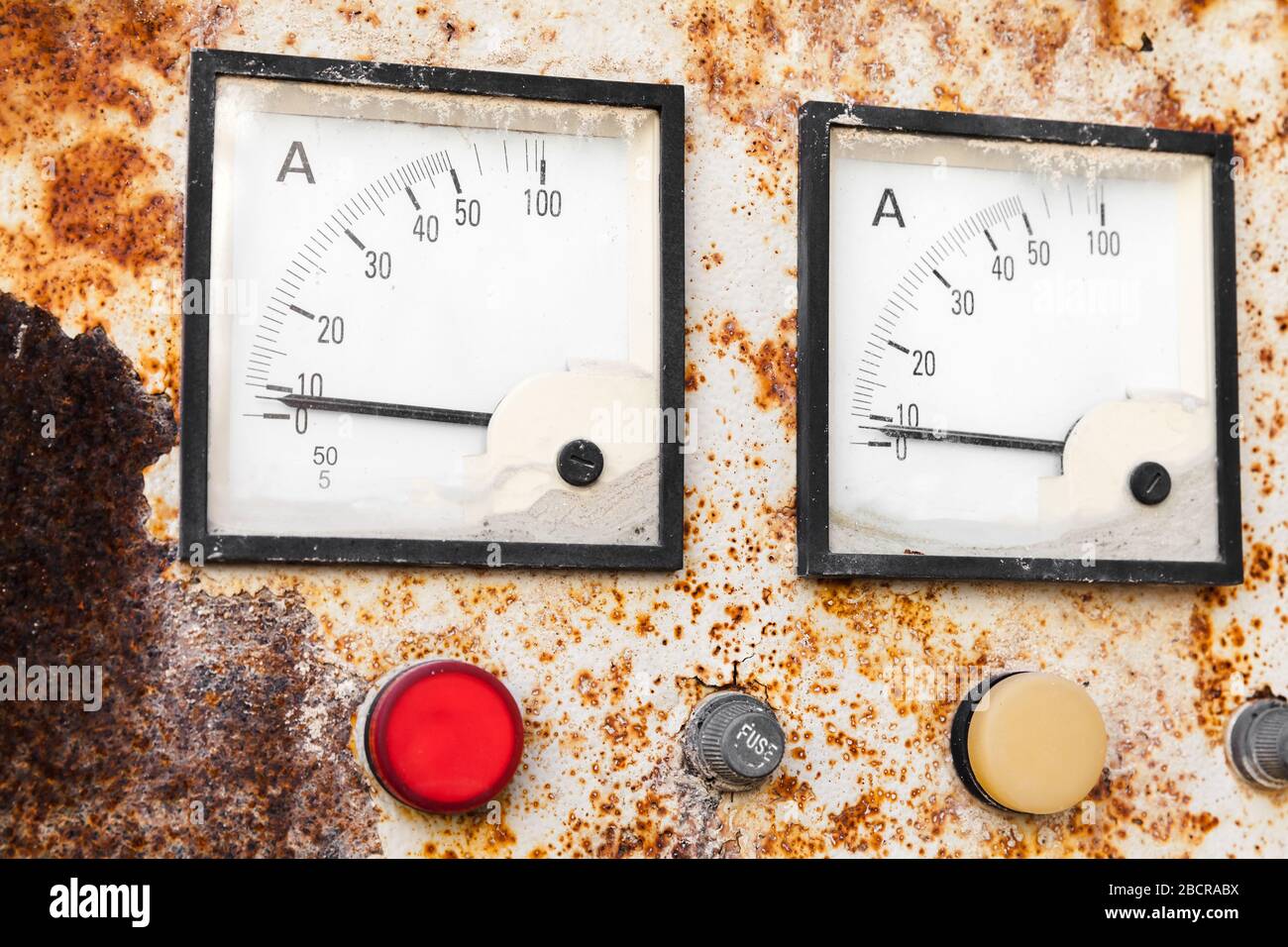 Two industrial square ammeters show zero power level, close up photo of a rusty old electric control panel Stock Photo