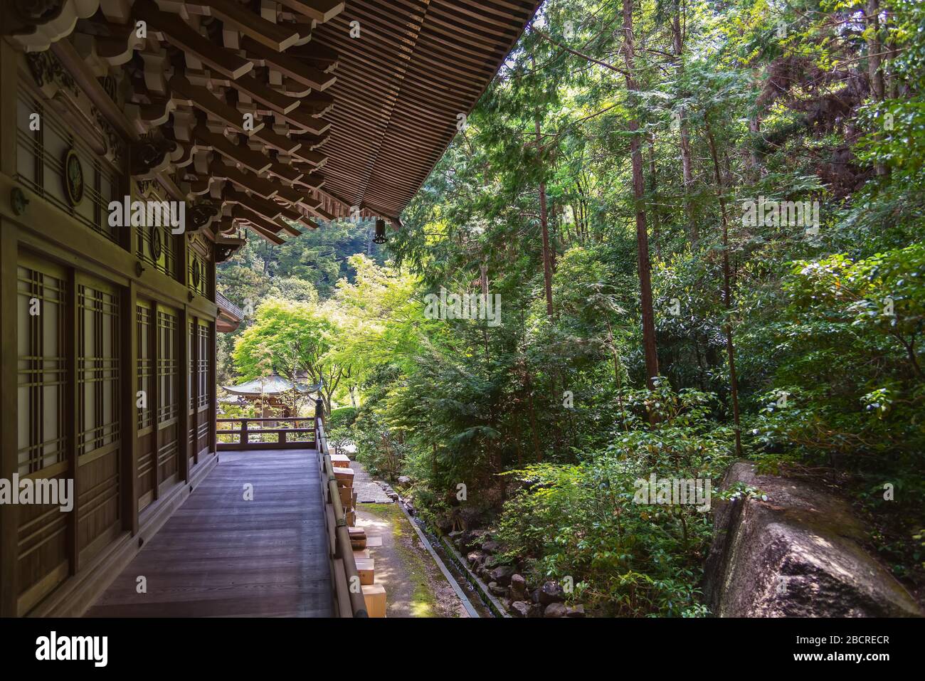 Itsukushima, Japan - April 27, 2014: The Maniden Hall and the forest in Daisho-in temple complex. This is the main prayer hall of the complex Stock Photo
