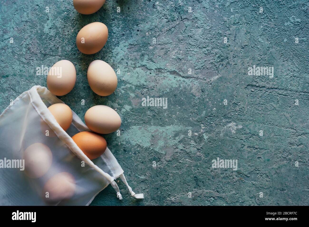 Eggs scattered from a textile white reusable shopping bag. Stock Photo