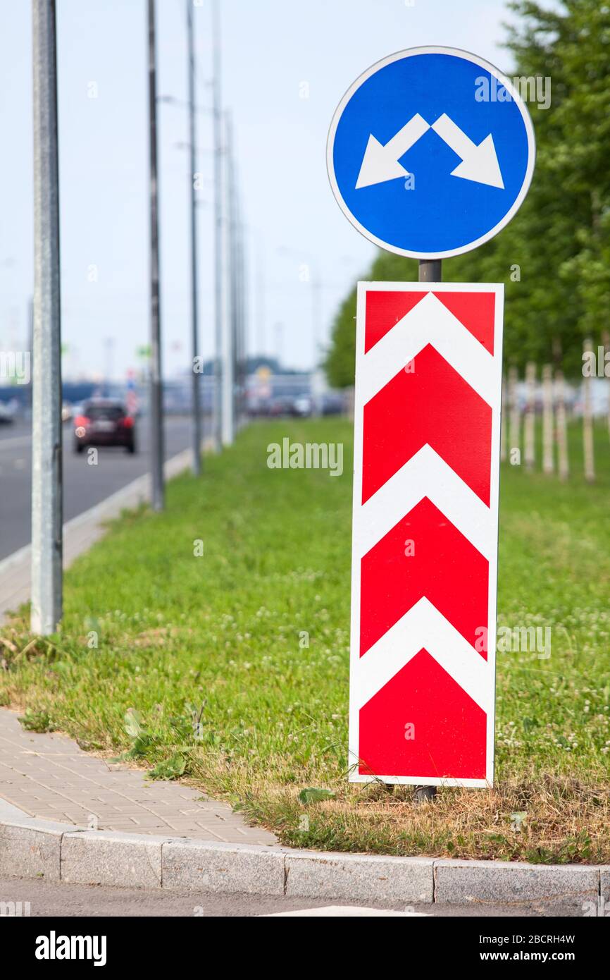 Road sign with two directions for driving, an asphalt roadside at summer Stock Photo