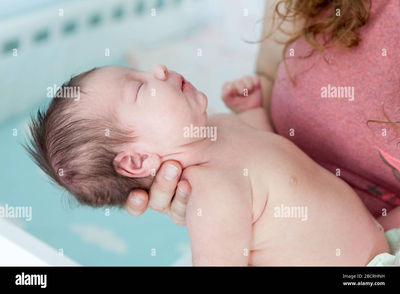Newborn Caucasian baby fall into a deep sleep on female hands, throw back head Stock Photo Alamy