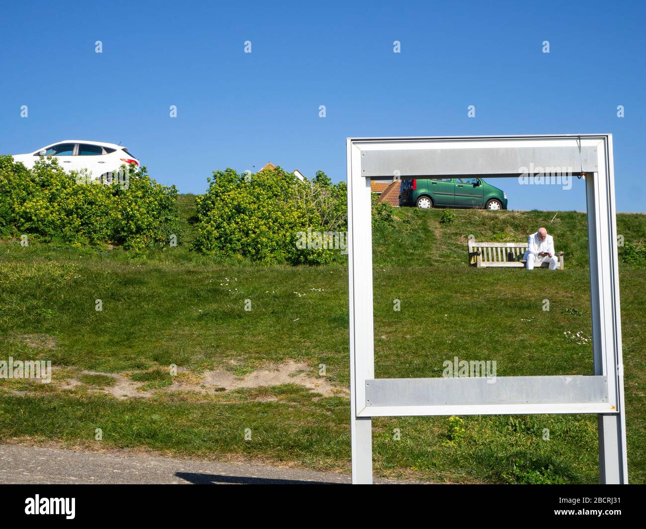 Man in a white suit sitting alone on a park bench Stock Photo - Alamy