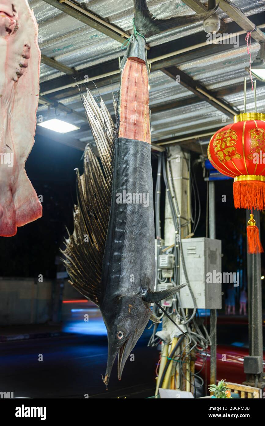 Sailfish hanging from the roof in a restaurant kitchen with steaks cut from its tail, Kata Beach, Phuket, Thailand Stock Photo