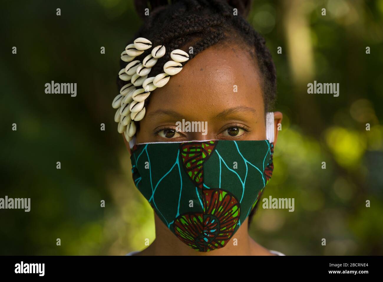 A Kenyan woman wearing a homemade mask made out off traditional Kanga fabric for protection against covid-19 pandemic. Surgical masks are in short sup Stock Photo
