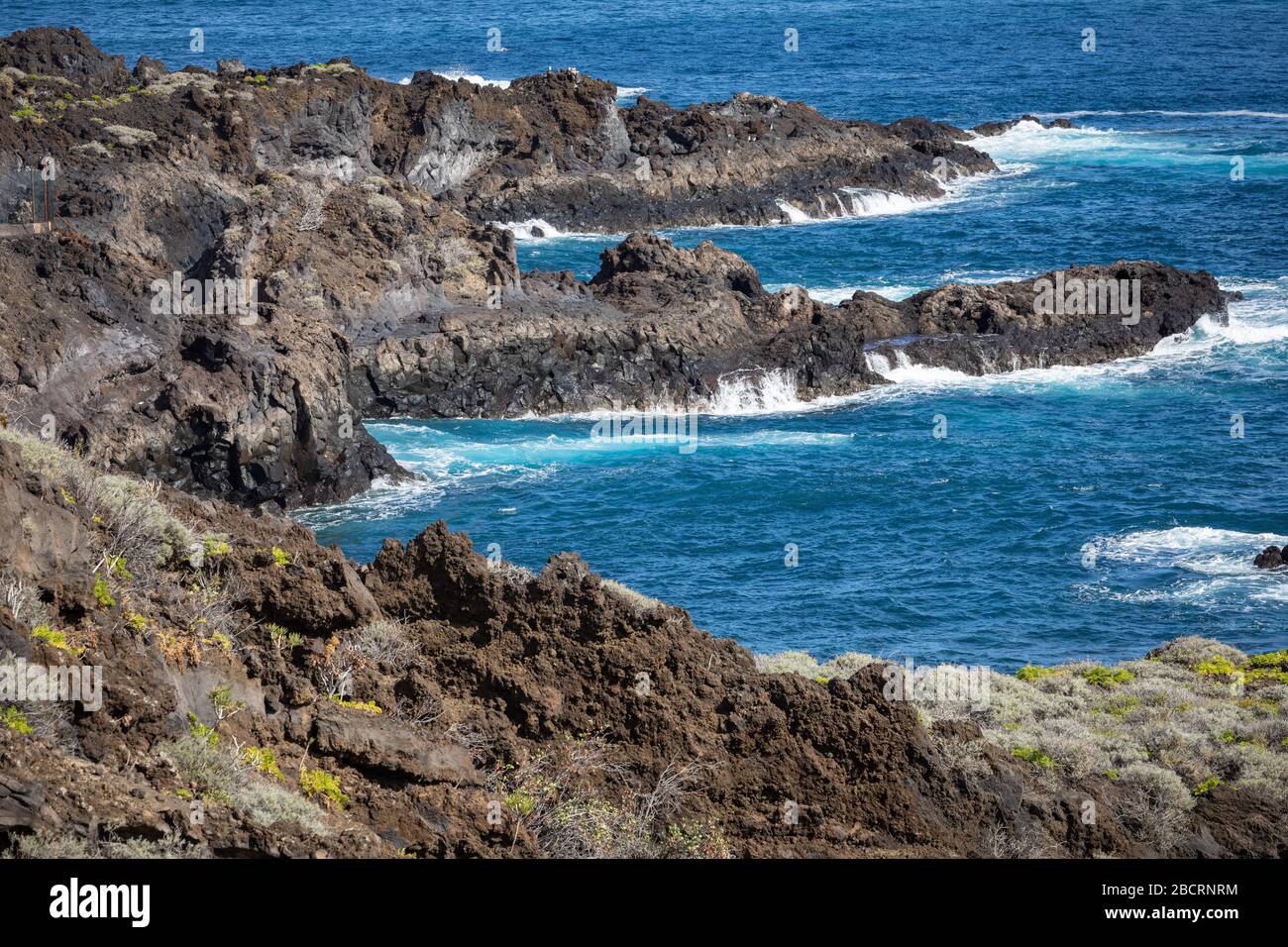 Volcanic Rock Formation, Cliffs Of Black Lava On The Rocky Shore With 