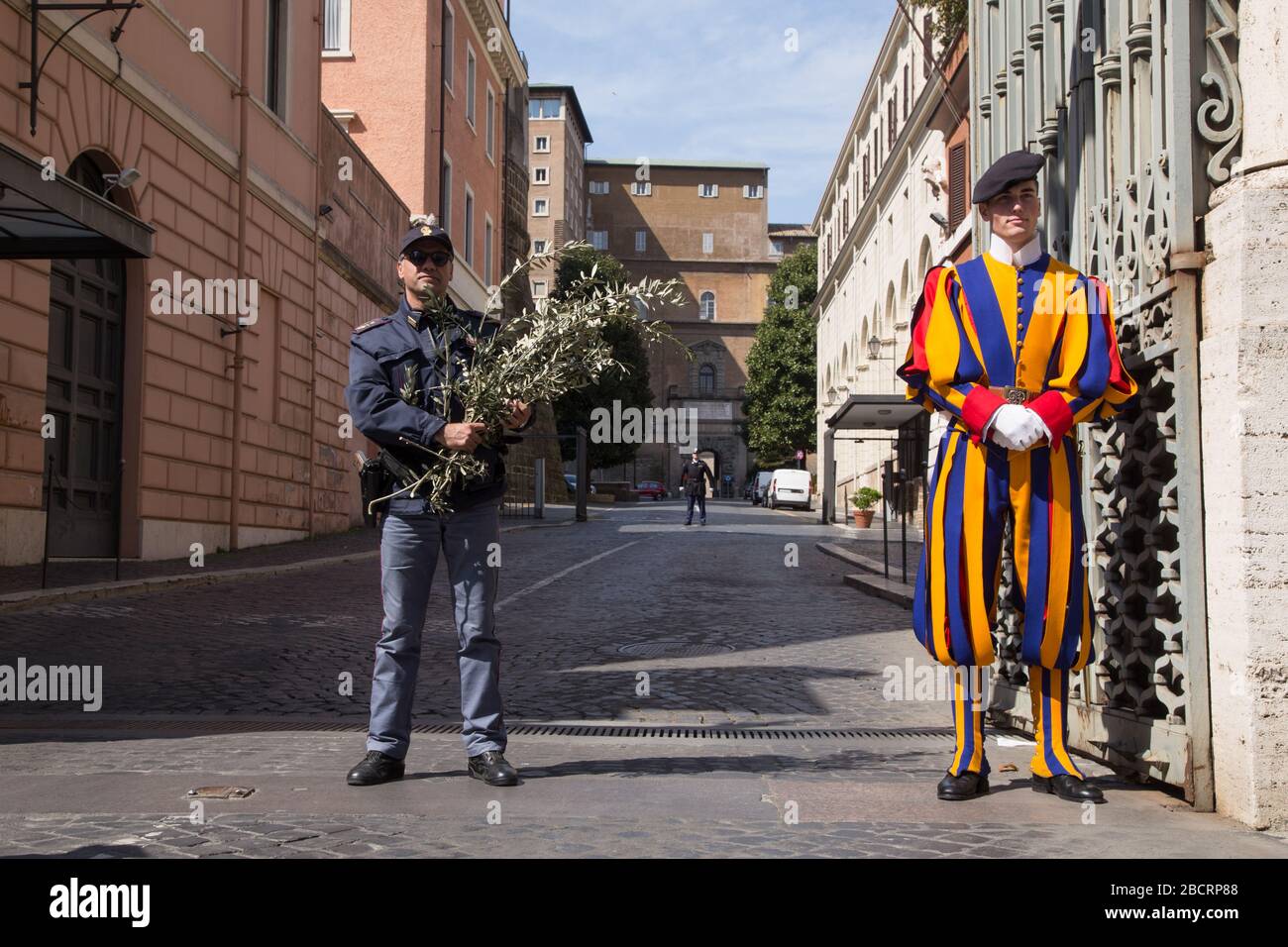 View of the Porta Sant'Anna of the Vatican City with carabinieri and a  Swiss guard Palm Sunday in St. Peter's Square in Rome in this lockdown  period due to the Covid-19 pandemic (