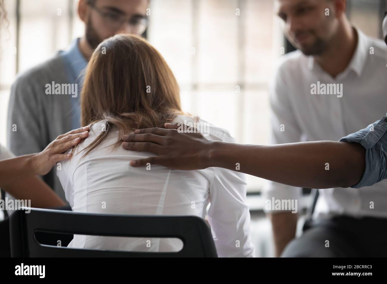 Close up back view unhappy woman with supporting diverse people. Stock Photo
