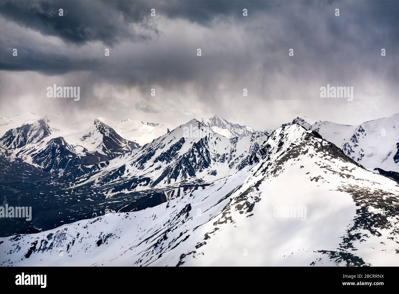 Landscape of Snowy Mountains with overcast stormy sky background Stock Photo