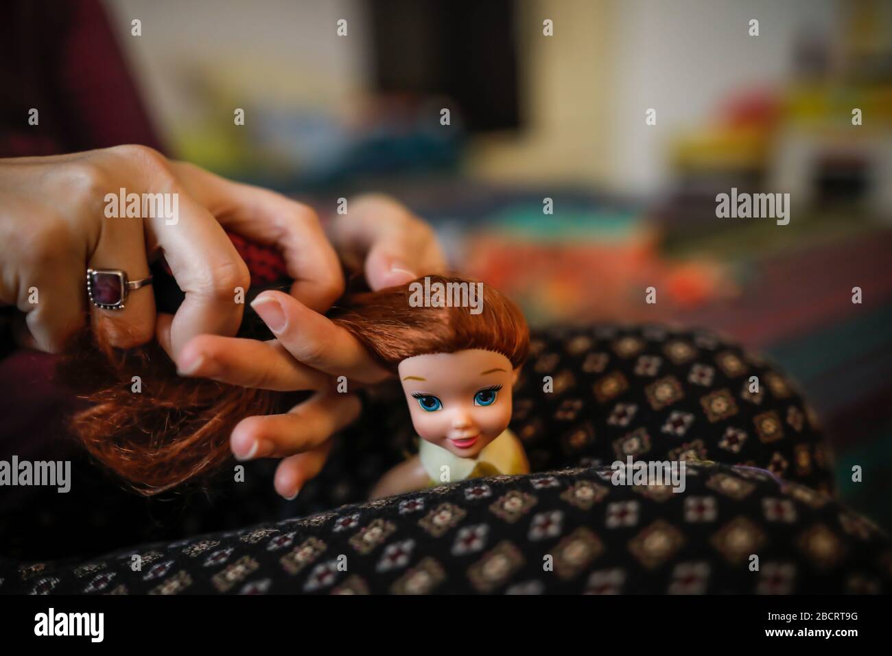 Details with the hands of a mother brushing and arranging the hair of