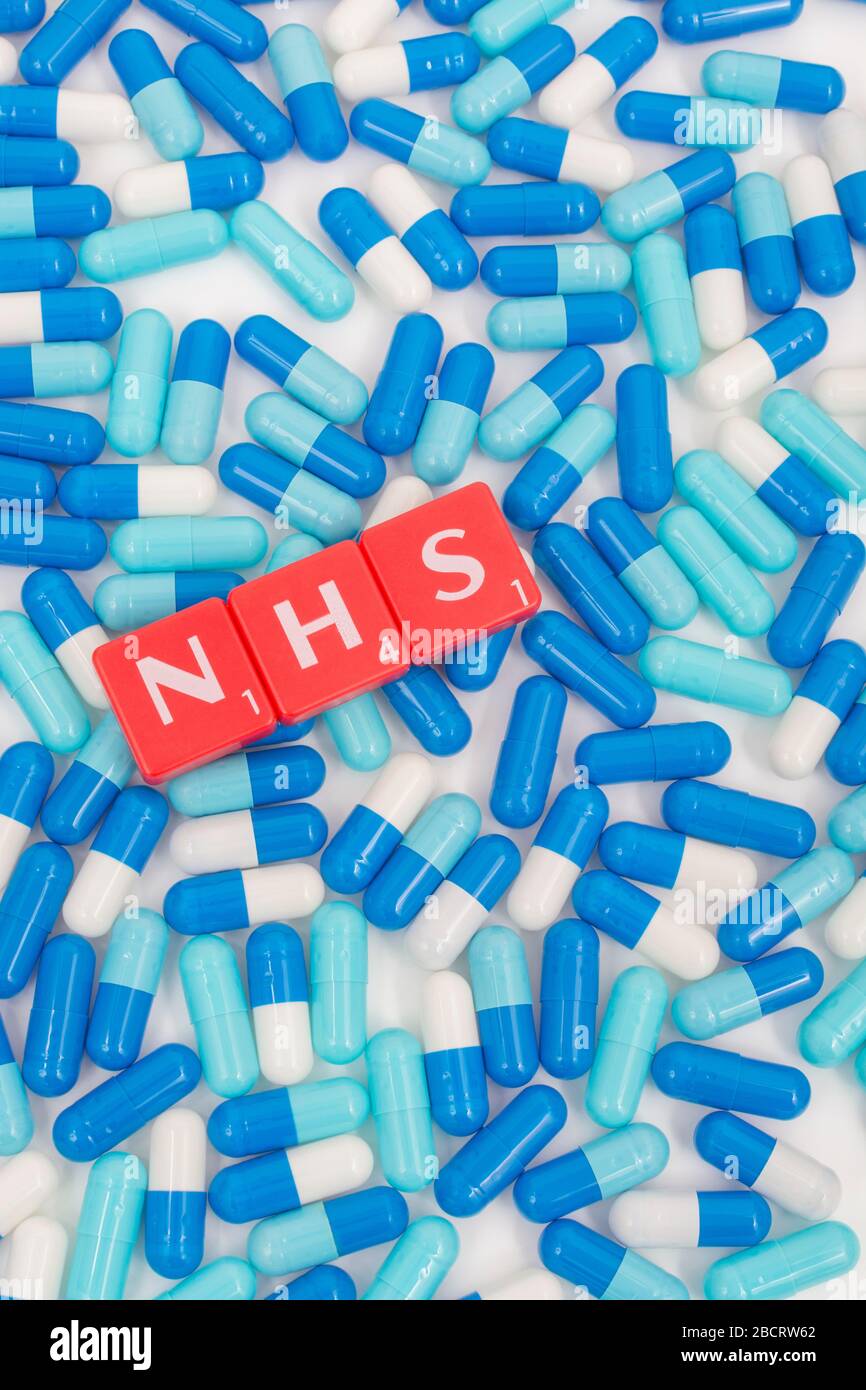 NHS letters tiles & assorted blue pills. Metaphor NHS in Covid 19 pandemic, NHS heroes, NHS prescriptions, UK National Health Service, medicine in UK Stock Photo