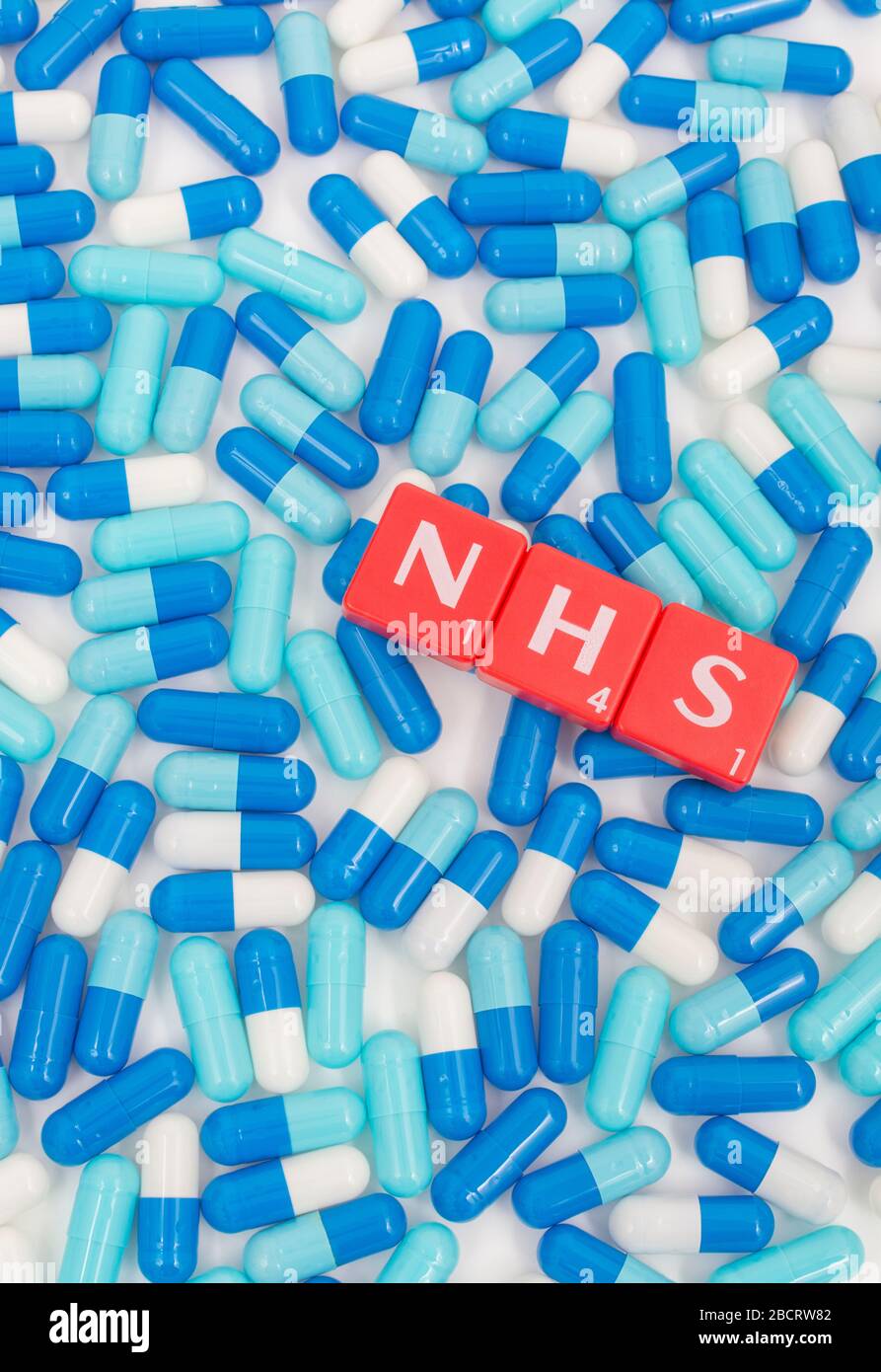 NHS letters tiles & assorted blue pills. Metaphor NHS in Covid 19 pandemic, NHS heroes, NHS prescriptions, UK National Health Service, medicine in UK Stock Photo