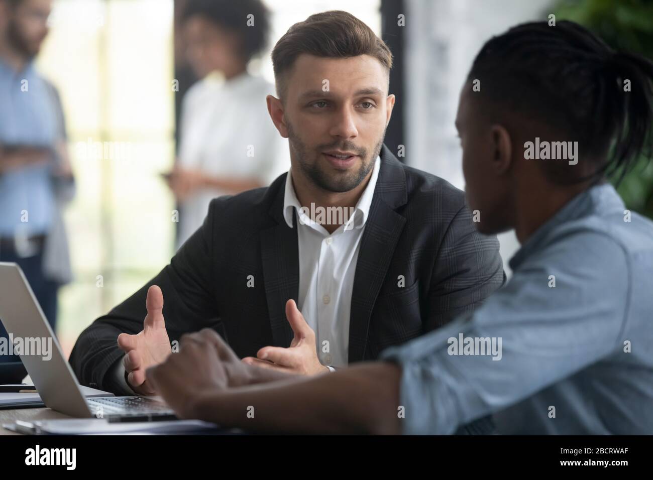 Close up confident businessman talking with african american businessman. Stock Photo