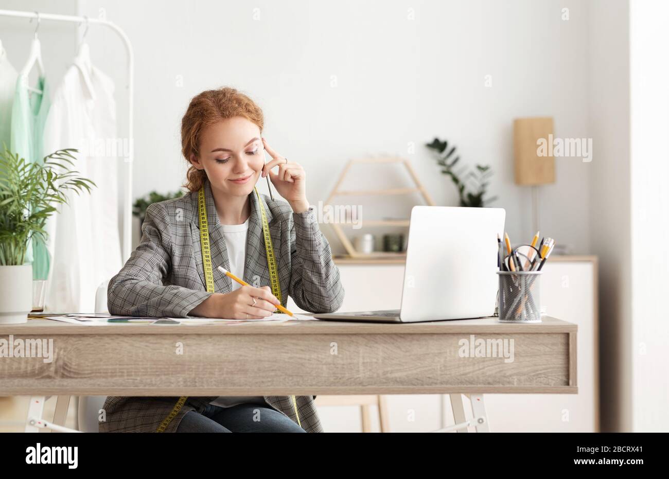 Female tailor talking on mobile phone with customer Stock Photo
