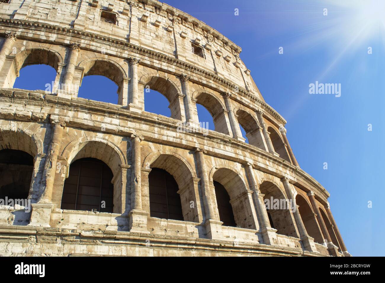 Colosseum at blue sky with sunlight. Rome ancient arena for gladiator fights in Italy Stock Photo