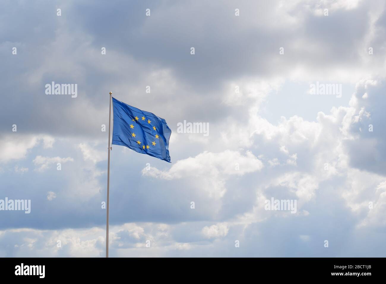 Official flag of European Union in the sky. Circle of yellow stars on blue background Stock Photo