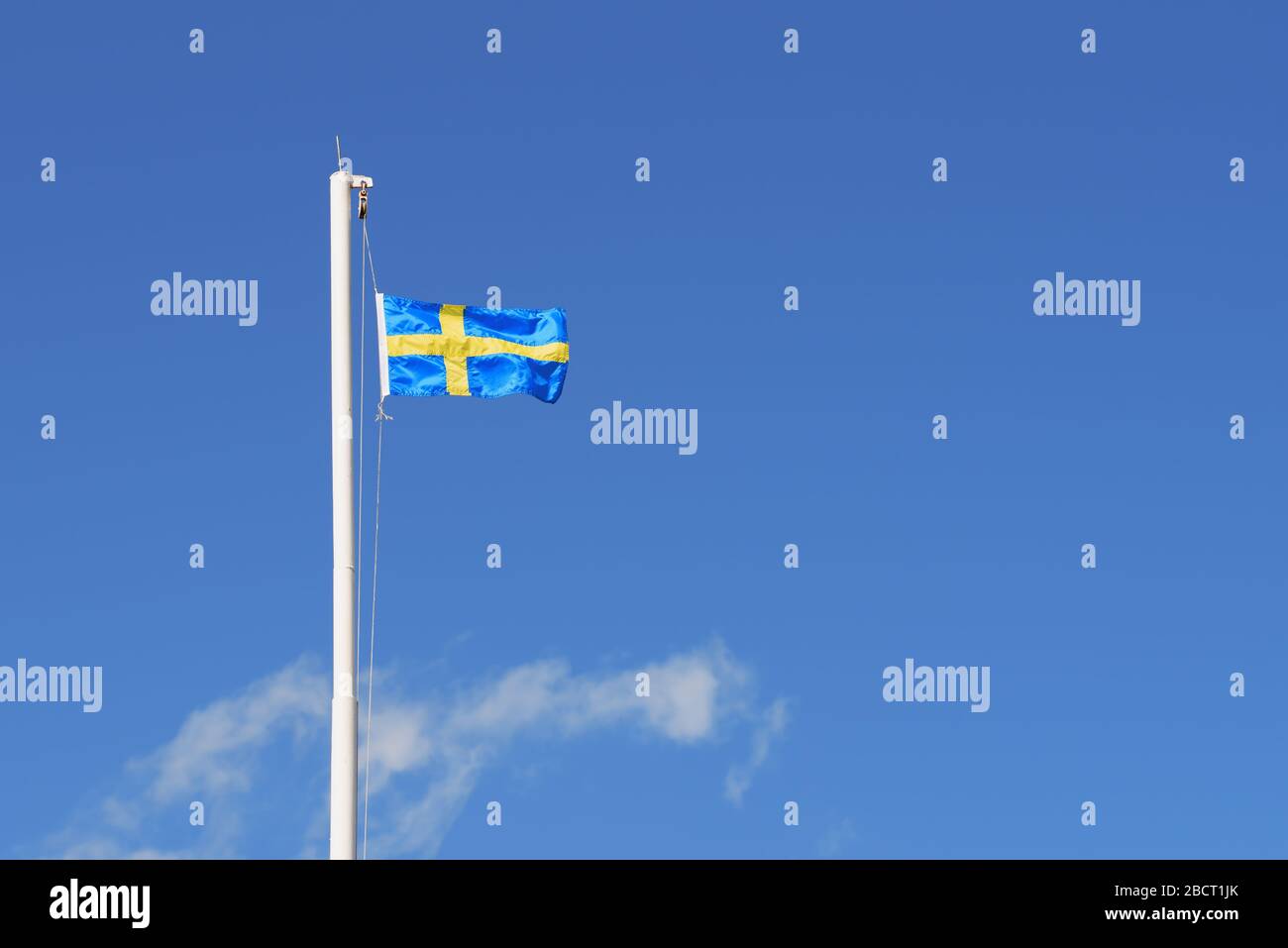 Official flag of Sweden in the sky. Cross of yellow strips on blue background Stock Photo