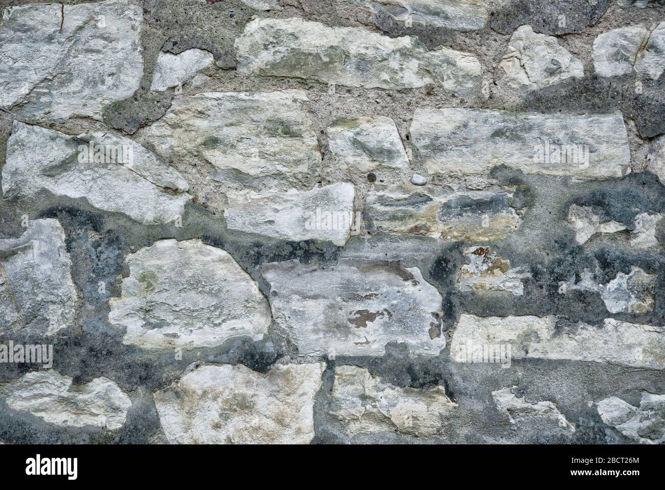 Ancient grey round stone wall flat background closeup Stock Photo