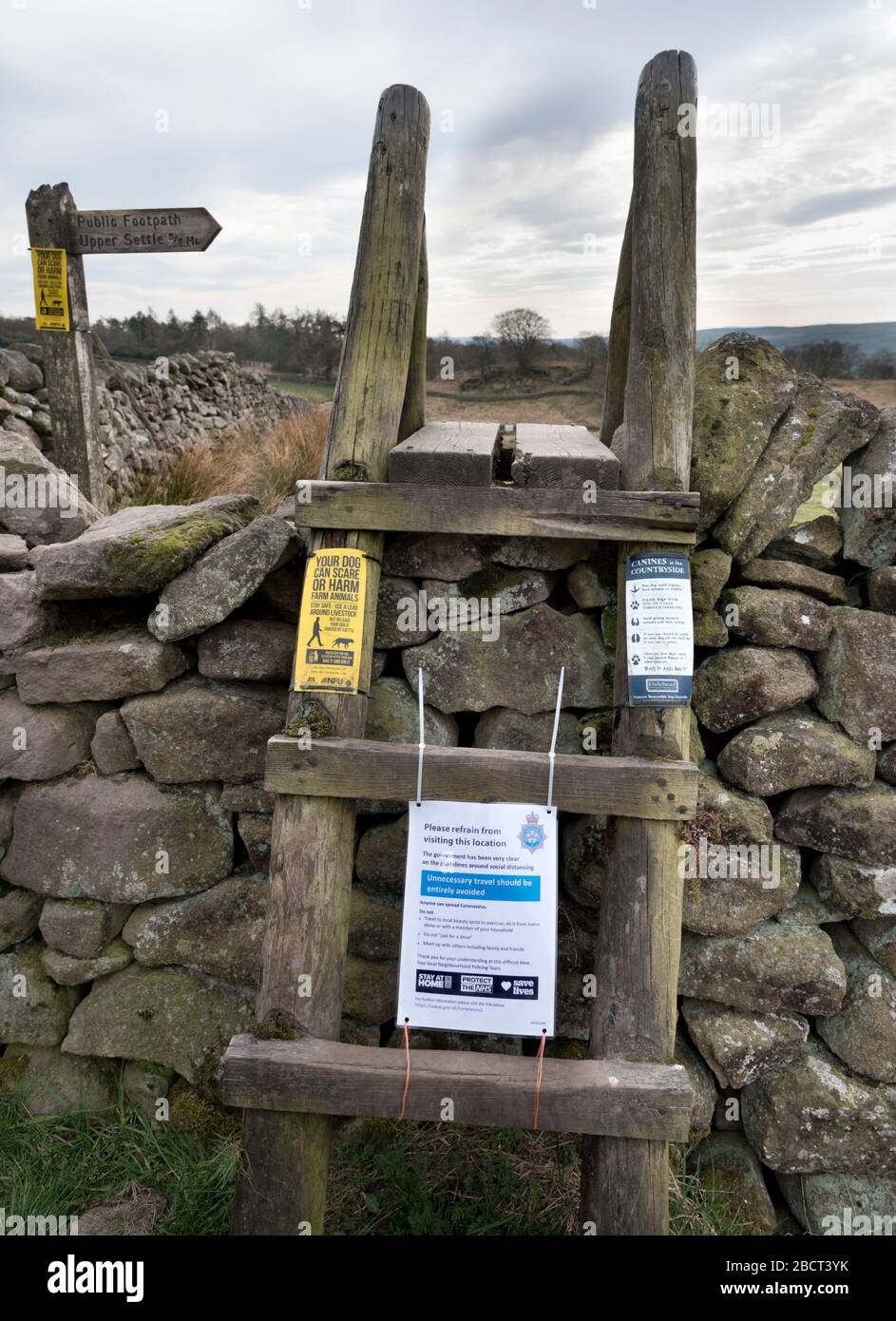 Settle, North Yorkshire, UK. 5th Apr 2020. Coronavirus 'shutdown'. North Yorkshire Police notice on public footpath ladder stile, Yorkshire Dales National Park near Settle. The sign says 'do not travel to local beauty spots to exercise, do it from home'. Other signs are the usual warnings about dogs on leads.  Credit: John Bentley/Alamy Live News Stock Photo