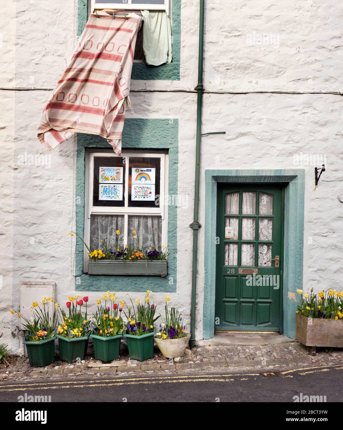 Settle, North Yorkshire, UK. 5th Apr 2020. Coronavirus 'shutdown': cottage with 'Thanks you NHS and Keyworkers' rainbow posters, Settle, North Yorkshire. Credit: John Bentley/Alamy Live News Stock Photo