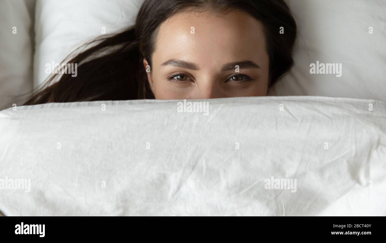 Happy girl hide under blanket relaxing in bed Stock Photo Alamy