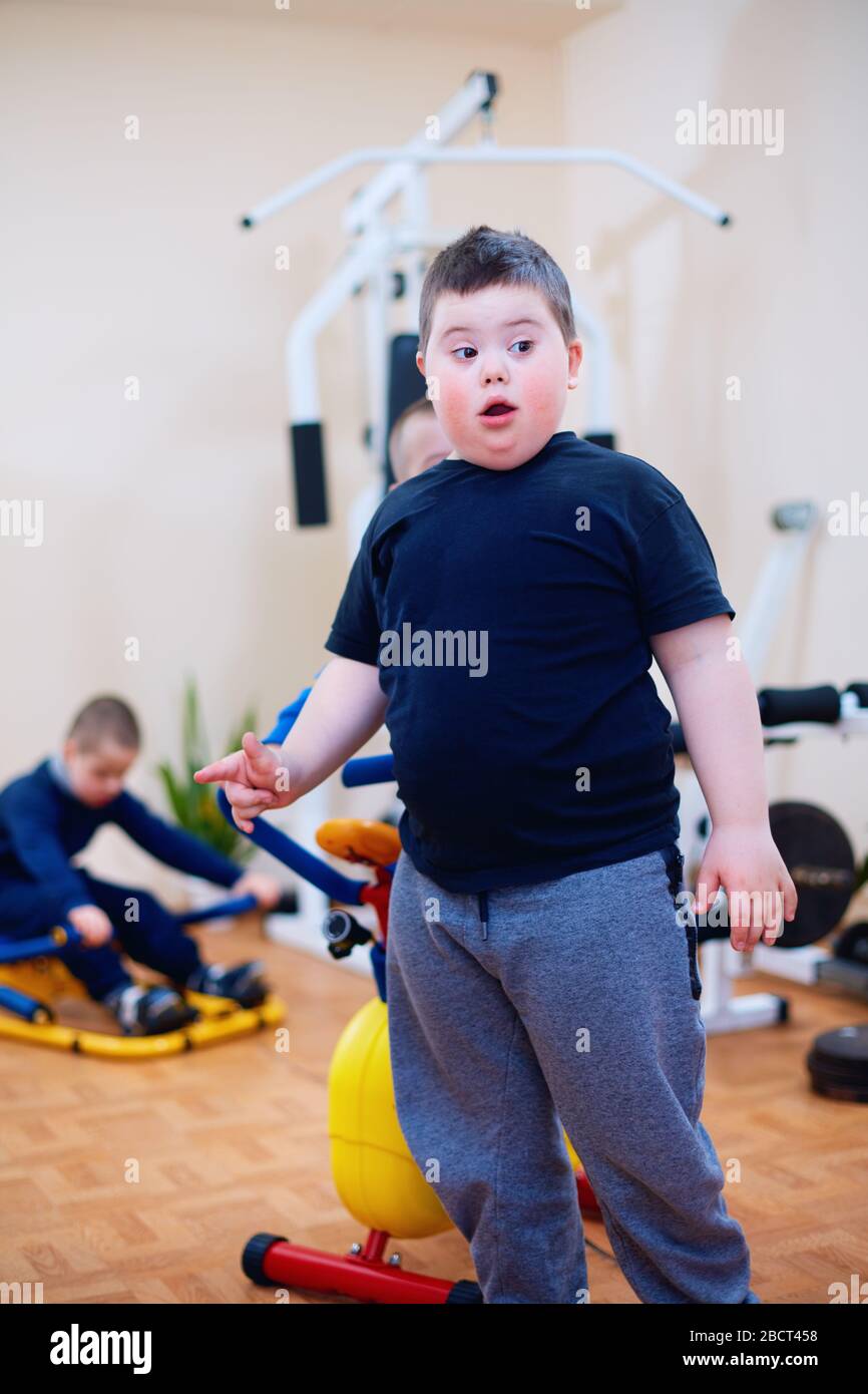 cute kid with down syndrome at inclusive sport center for kids with special needs. living a full life Stock Photo