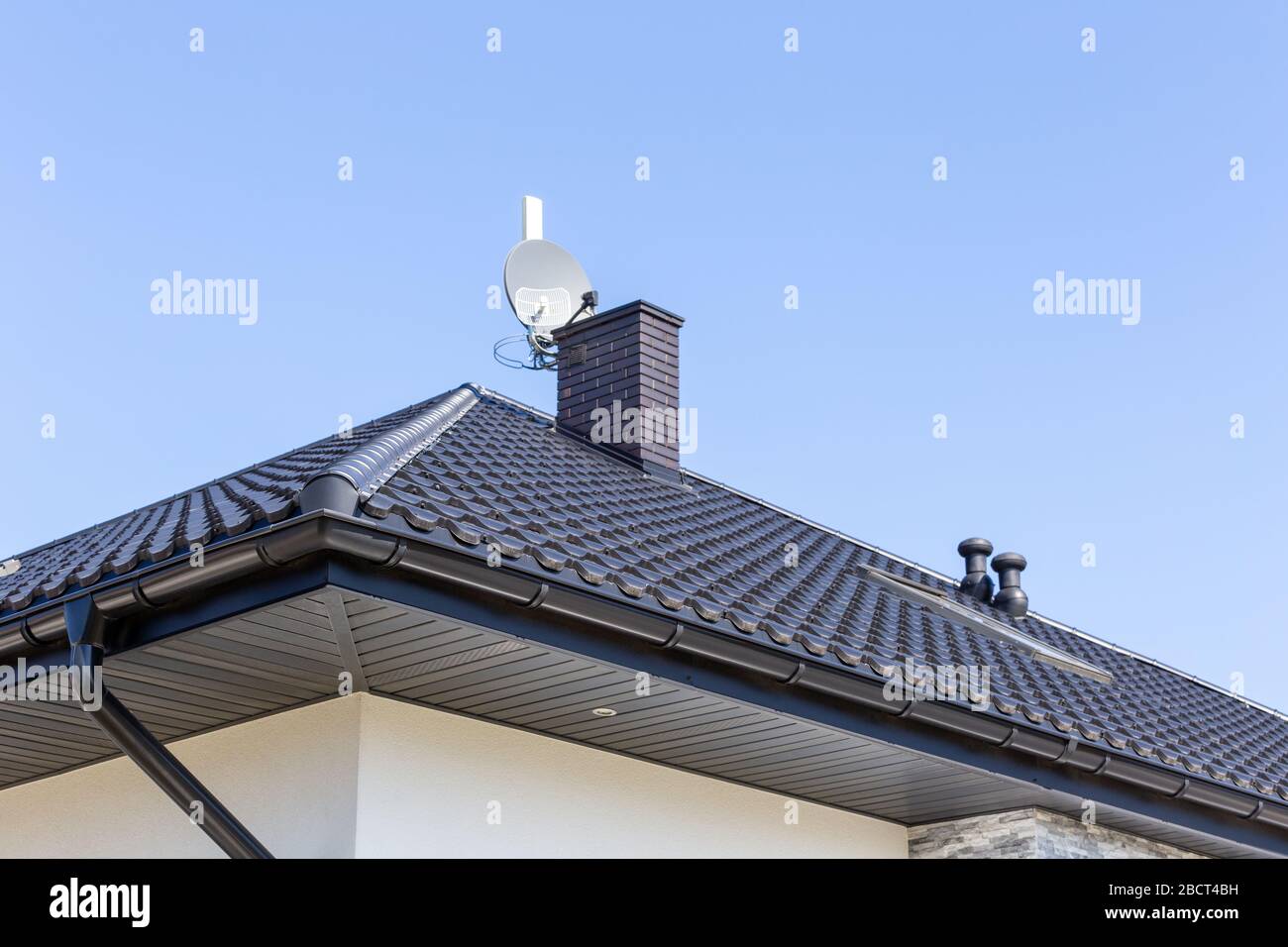 Corner of the new modern house with gutter, ventilation chimneys and
