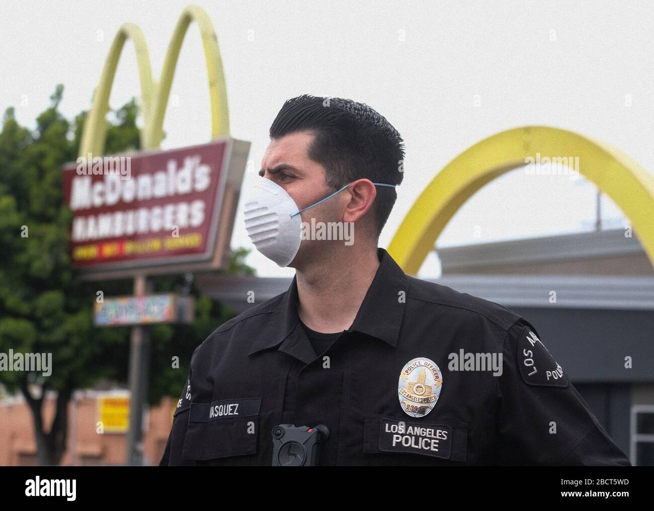 Los Angeles, California, USA. 5th Apr, 2020. A police officer wearing a face mask as workers take part in a drive-thru ''strike'' at a McDonald's restaurant on Sunday, April 5, 2020 in Los Angeles. The workers are demanding a two-week quarantine period, with full pay for a co-worker who tested positive for COVID-19. Credit: Ringo Chiu/ZUMA Wire/Alamy Live News Stock Photo