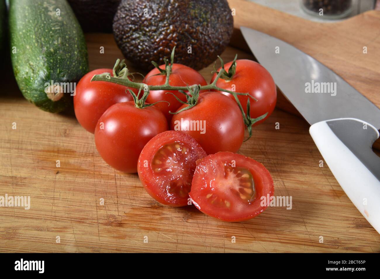 Fresh Vine Ripened Pearl Tomatoes On A Cutting Board With Avocado