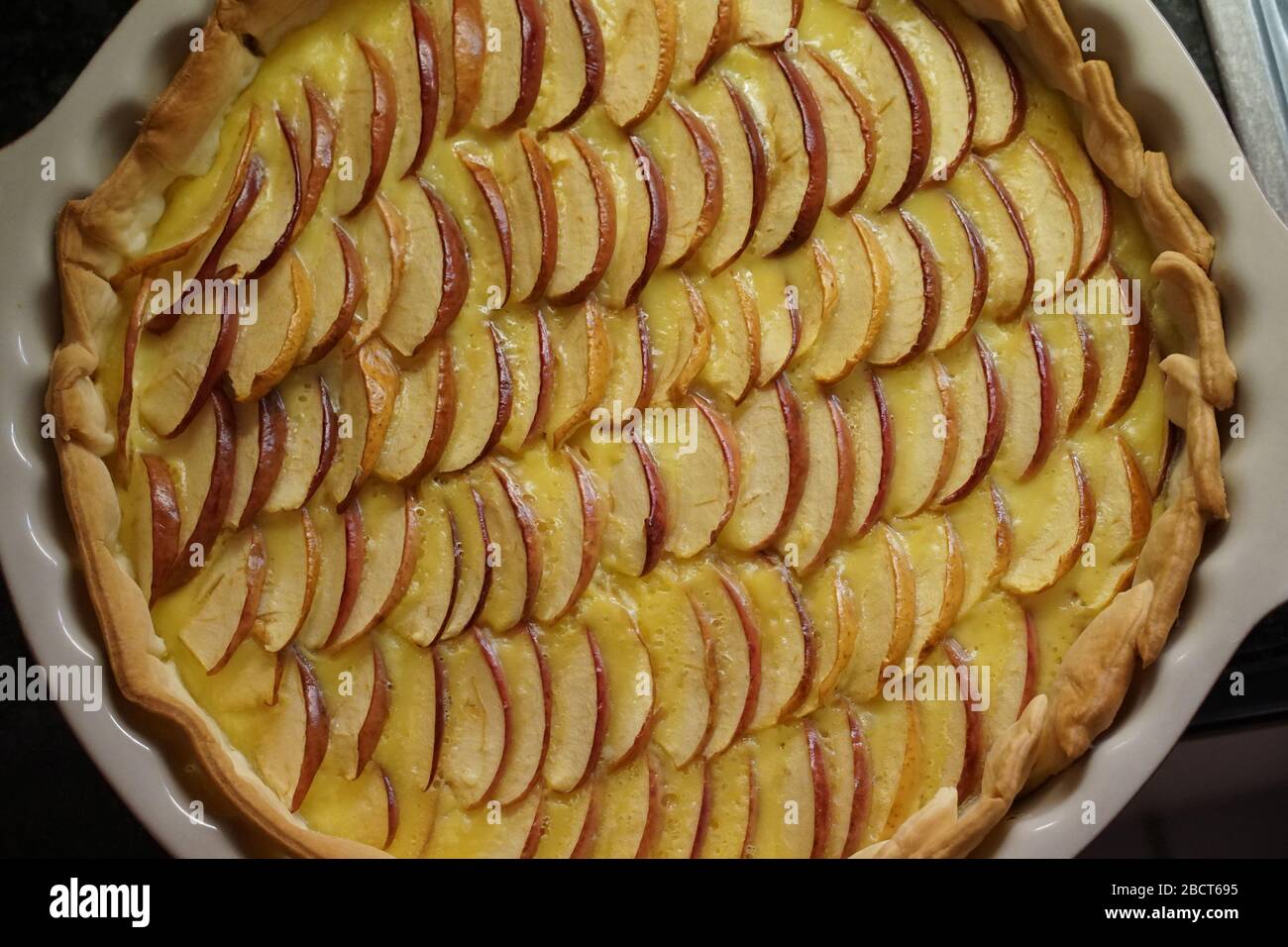 sweet apple quiche apple pie in detail with apple slices in neat rows, covered by thin layer of custard Stock Photo
