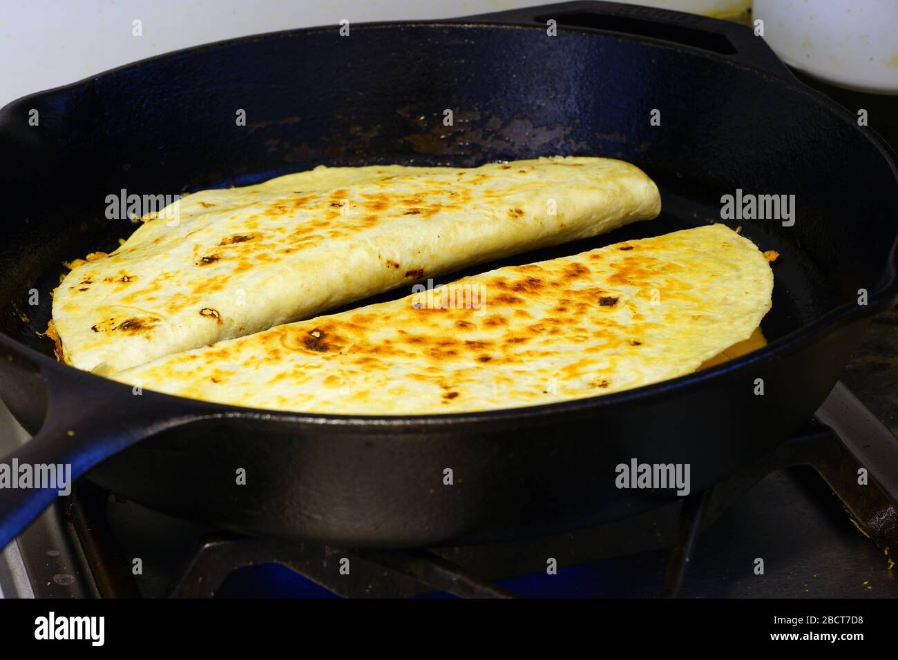 Cooking quesadillas in a castiron pan Stock Photo Alamy
