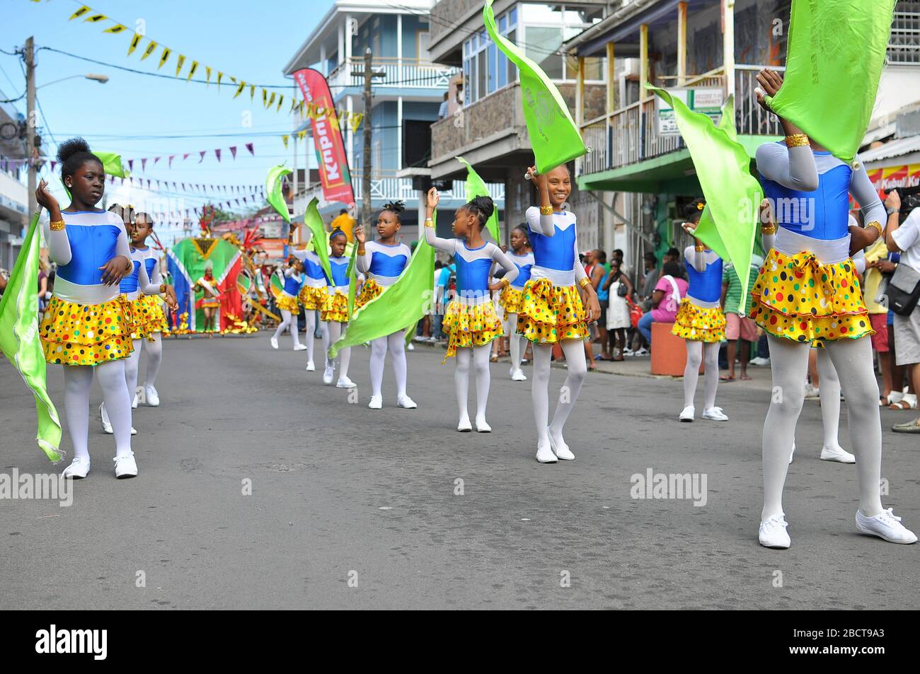 A group of children in costumes performing and dancing with flags in the  carnival parade in Dominica Stock Photo - Alamy