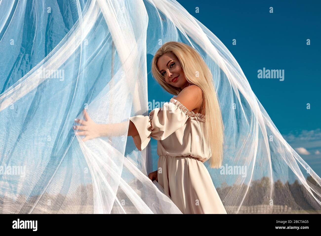 Portrait of a beautiful girl, blonde with long hair in the field, after ...