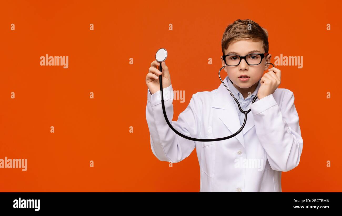 Little boy in medical uniform playing with stethoscope Stock Photo
