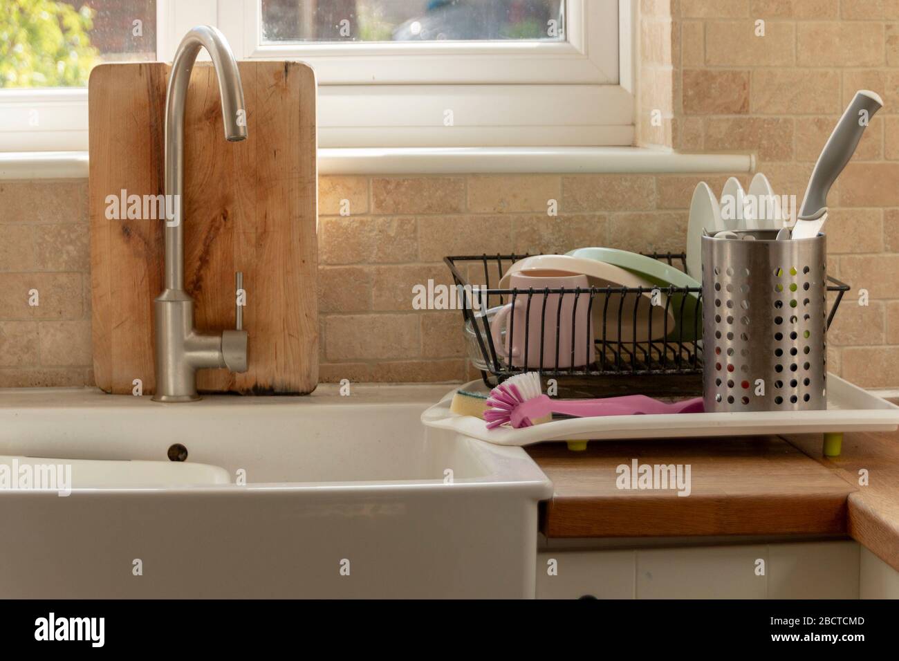 a close up view of clean dishing place in the drying rack in a open plan kitchen Stock Photo