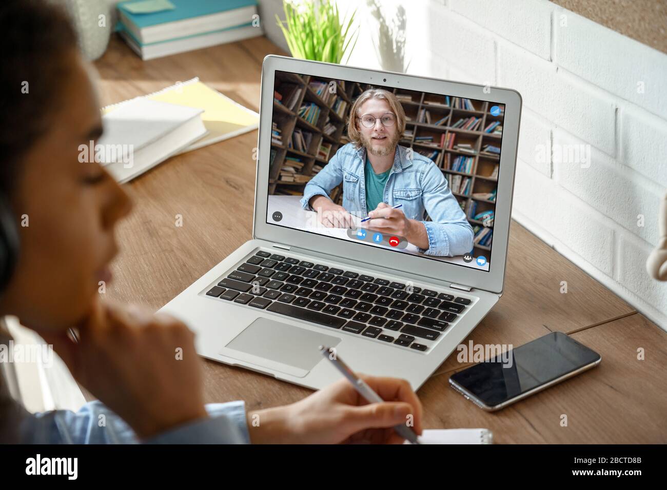 African girl college student studying with online teacher on computer screen. Stock Photo