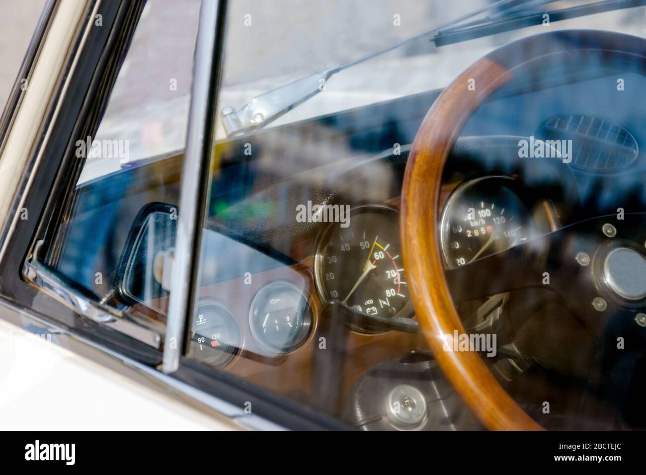 view of the steering wheel and dashboard of a car of the 70s. on glass ...