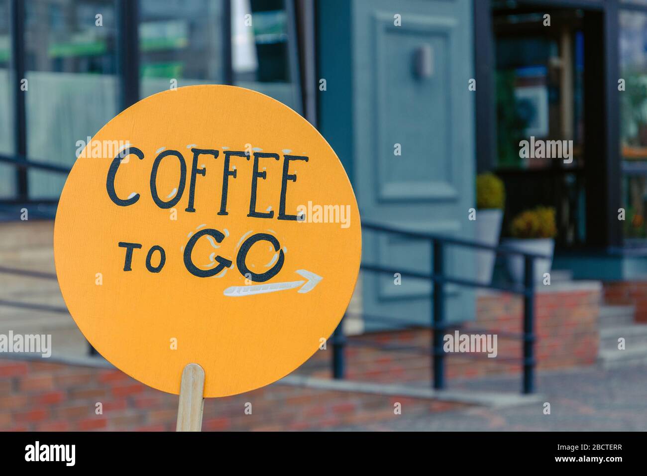 inscription coffee to go on an orange wooden plank. coffee shop, cafe advertisement. takeaway coffee Stock Photo