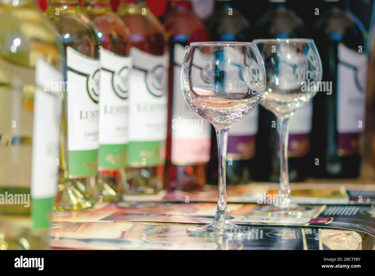 https://c8.alamy.com/comp/2BCTFBY/sumy-ukraine-august-25-2019-the-second-wine-festival-in-sumy-2-wine-glasses-stand-on-a-table-next-to-bottles-of-wine-sunny-2BCTFBY.jpg