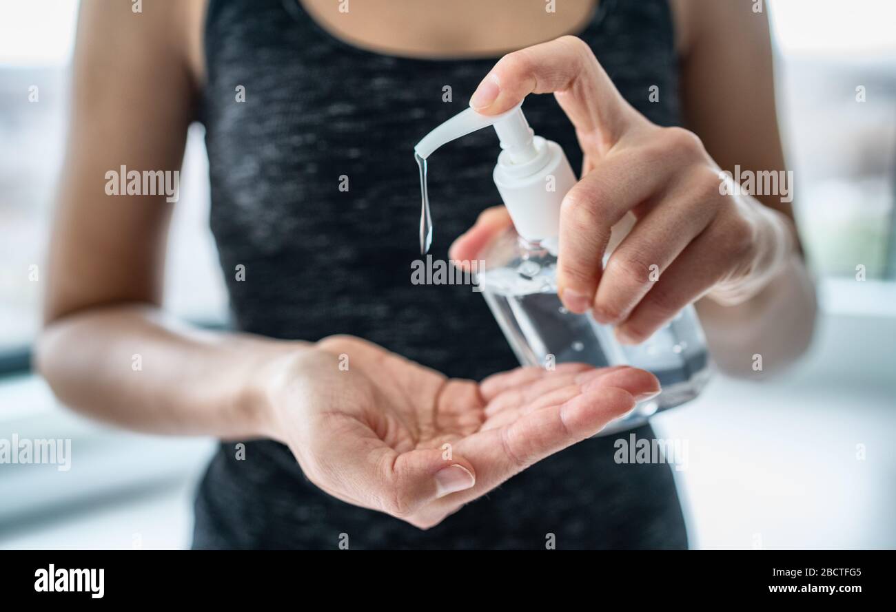 Hand sanitizer woman applying sanitizing gel liquid rubbing hands clean personal hygiene coronavirus pervention at home. Sanitiser bottle. Stock Photo